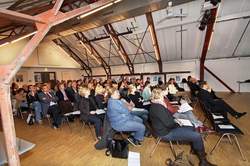 Personen sitzen in Stuhlreihen in einem großen Saal