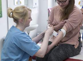 Pädiatrische Notaufnahme Pflegende verbindet Arm einer Patientin